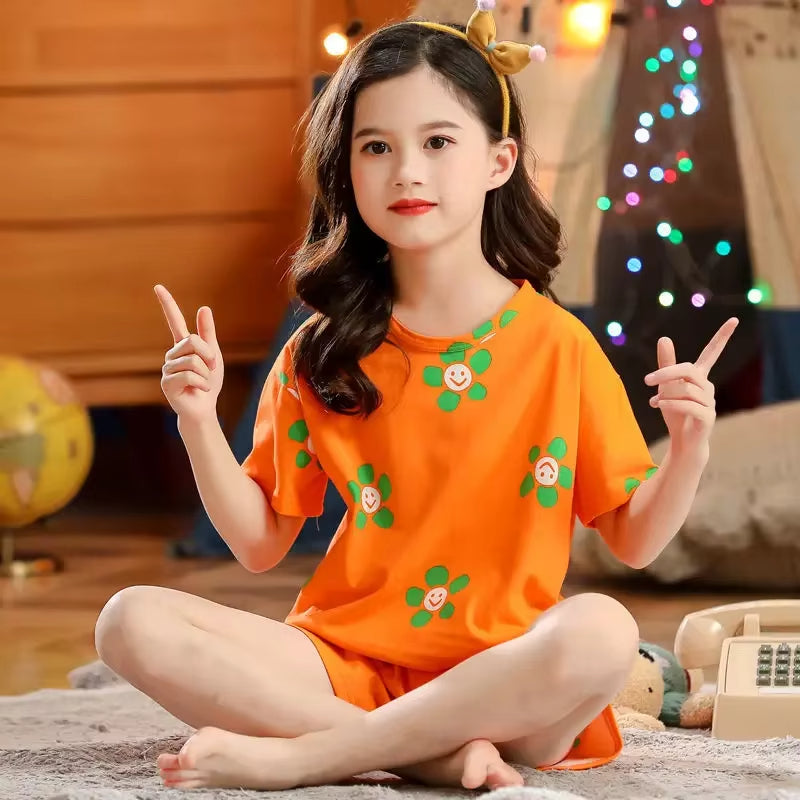 Girl wearing a cotton two-piece pyjama set with smiley flower print in a cosy setting