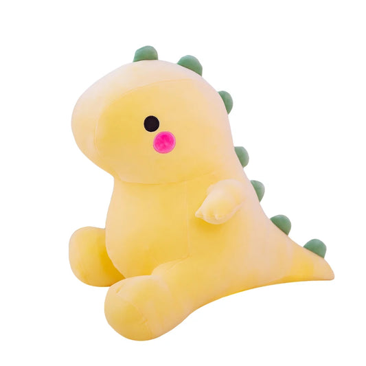 Yellow plush dinosaur toy with greens spikes on a white background.