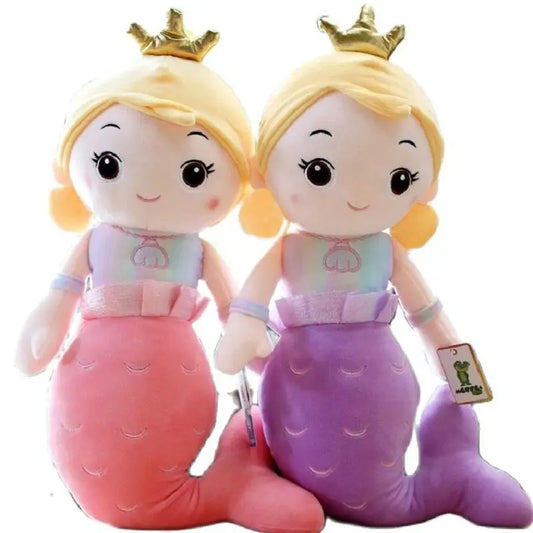 Two plush toys resembling mermaids with blonde hair and crowns on a white background.