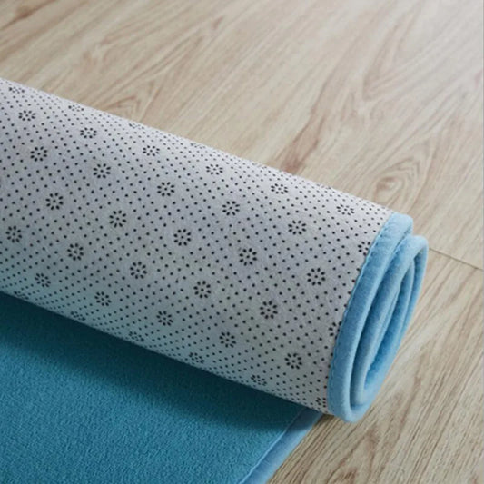 Rolled up blue rug showing the back fabric on a wooden floor