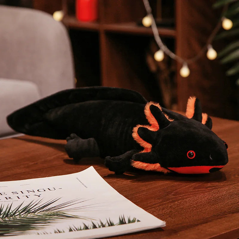 Plush axolotl toy on a wooden surface with a magazine underneath
