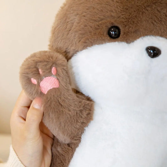 Close-up of a plush toy with a hand touching its paw, on a plain background