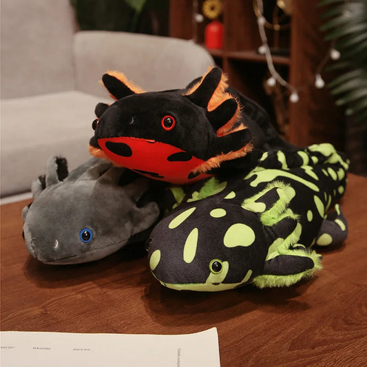 Three plush axolotls on a wooden surface with a blurred indoor background