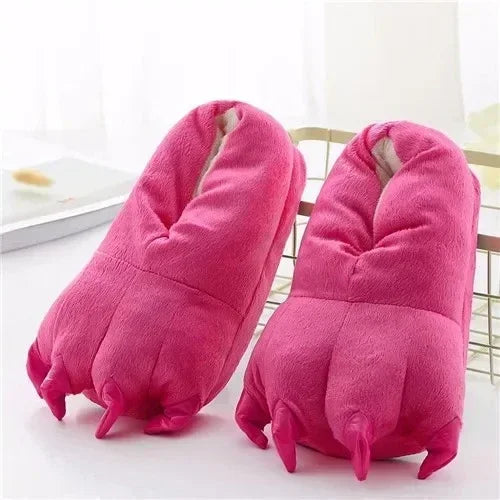 Pair of pink plush slippers on a light surface with a blurred background