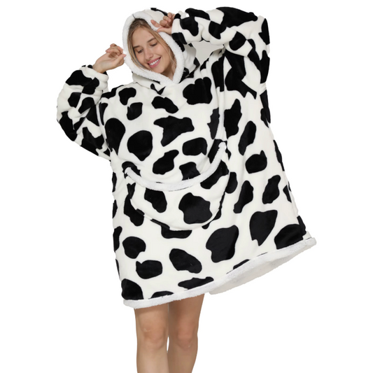 Child wearing a cow print oversized wearable hoodie with hood and front pocket.