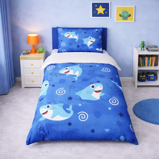 Children's bedroom with blue shark-themed bedding set on a bed.