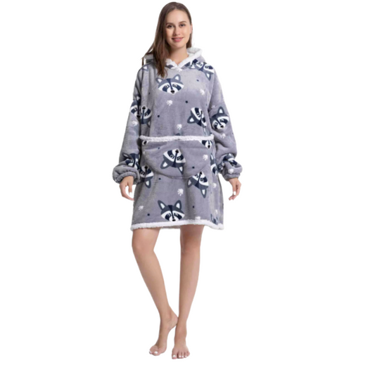 Woman wearing grey oversized wearable hoodie featuring a playful raccoon print and soft sherpa lining