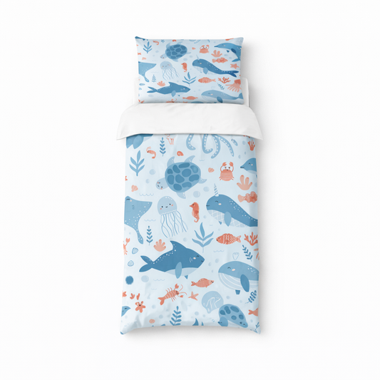 Ocean animal duvet set with whales, turtles and sea creatures on a soft blue background displayed on a single bed with matching pillowcase