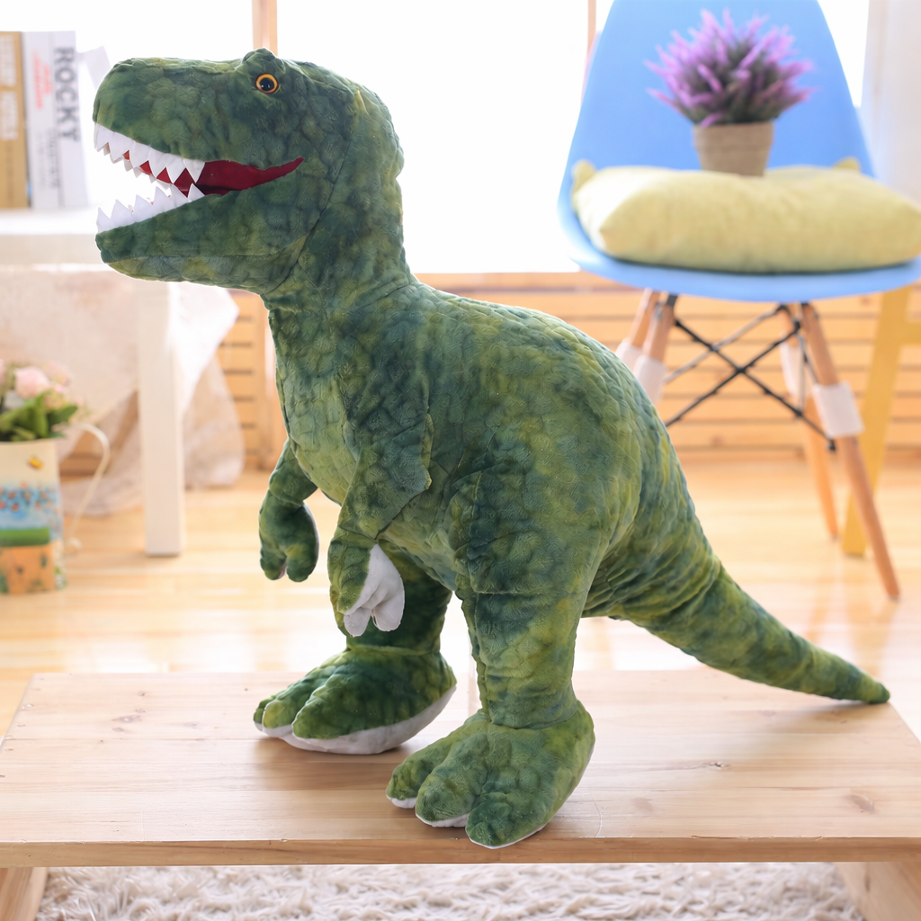 Green soft plush t-rex dinosaur on a wooden surface in a living room setting.