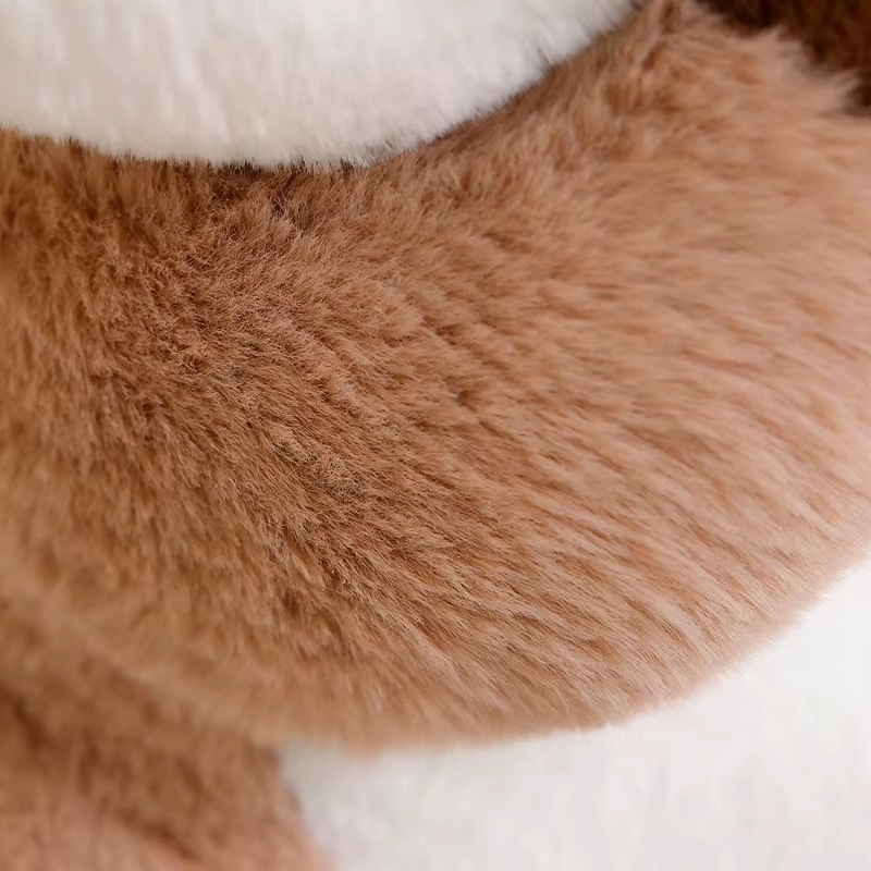 Close-up of brown plush fabric on an otter soft toy, showing the soft textured finish
