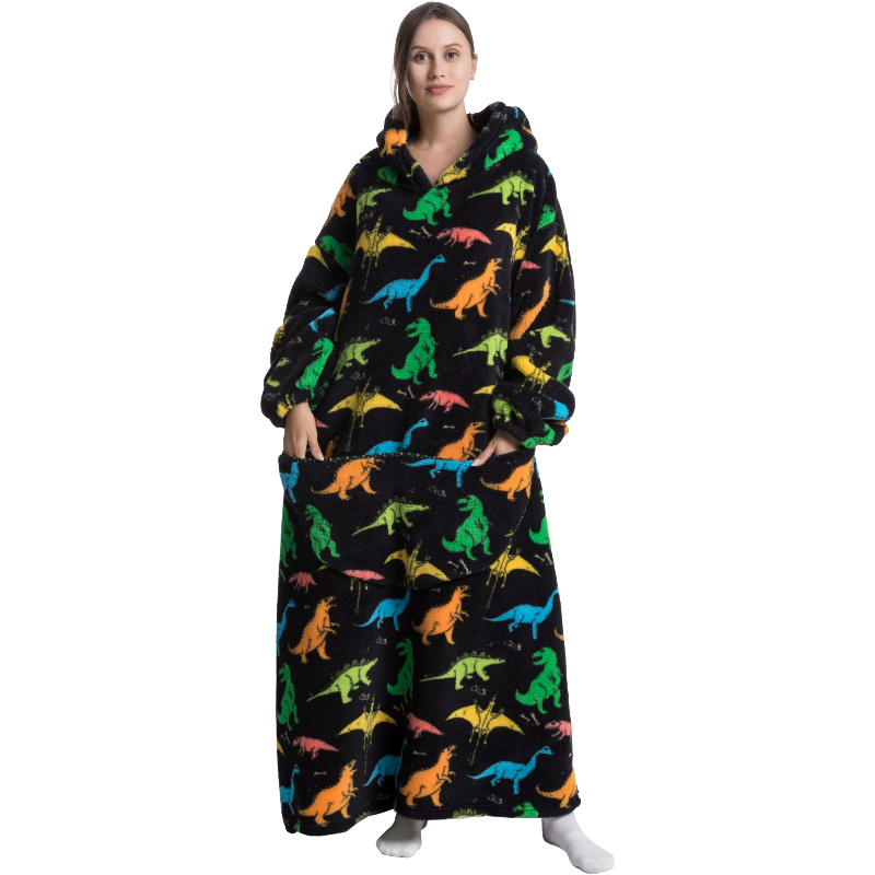 Person wearing a colourful dinosaur-patterned hoodie and blanket on a white background