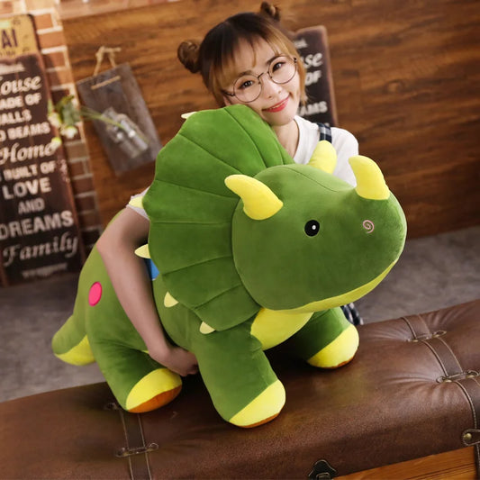 Woman holding a large green soft plush triceratops with yellow horns. 