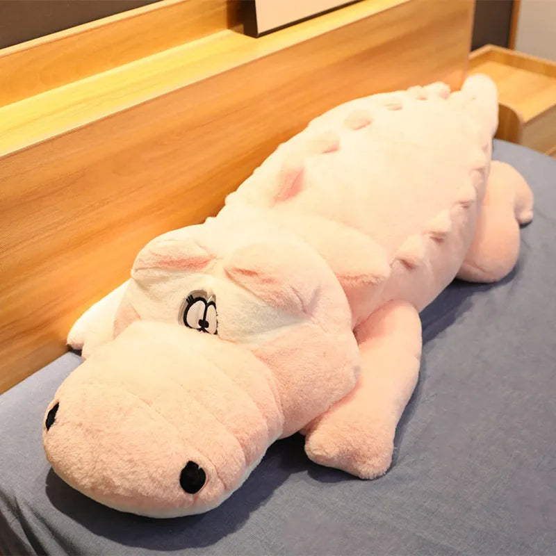 Big soft plush pink crocodile on a soft surface.