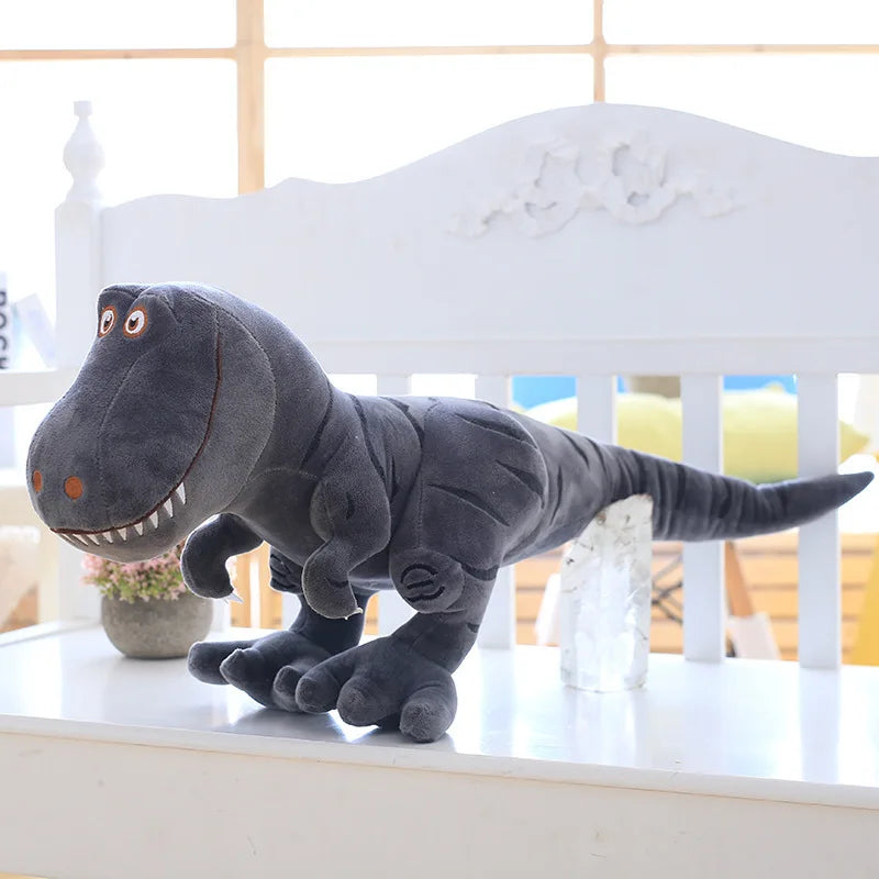 Grey dinosaur plush toy on a white surface with a blurred background