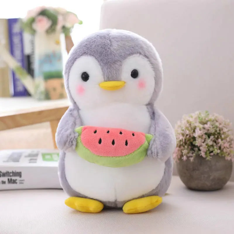Plush toy penguin holding a watermelon on a surface with a blurred background