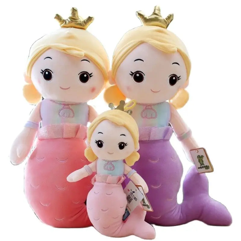 Three plush mermaid toys with blonde hair and crowns on a white background