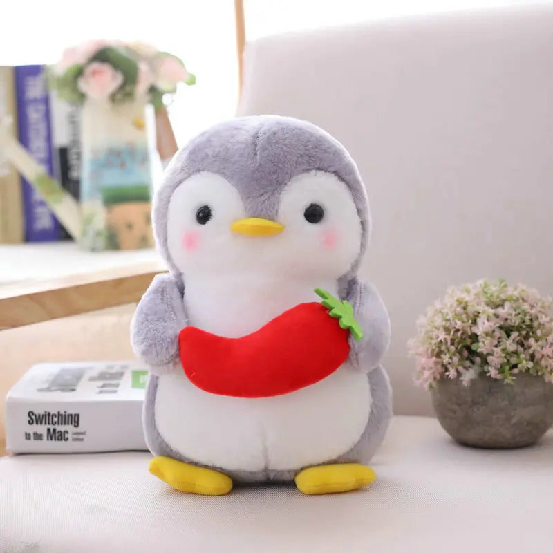 Plush toy penguin holding a red chilli on a cosy setting.