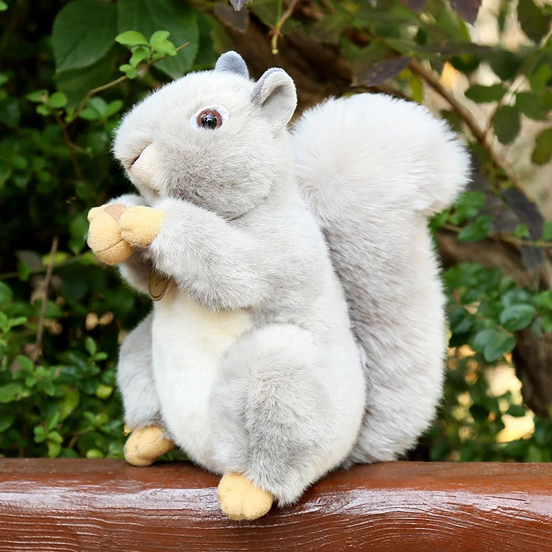Lifelike squirrel plush toy holding a hazelnut with fluffy tail and soft grey fur