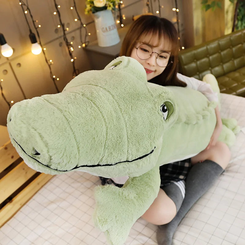 Large green soft plush crocodile toy being held by a woman.