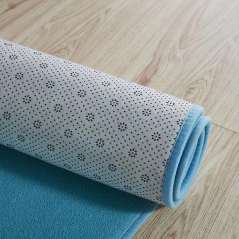 Rolled up blue rug showing the back fabric on a wooden floor