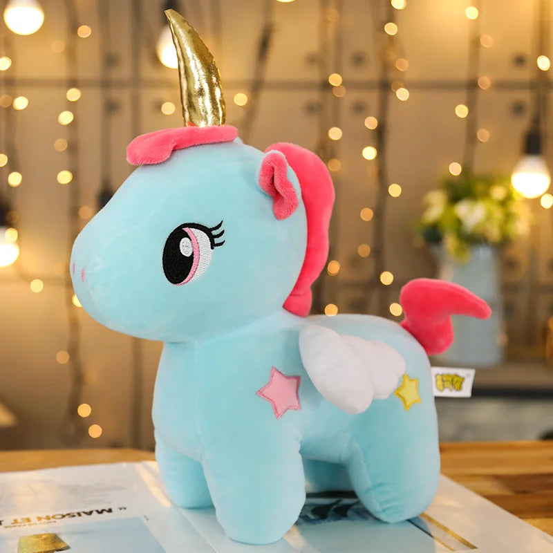 Blue unicorn plush toy with a gold horn on a magazine with a blurred background