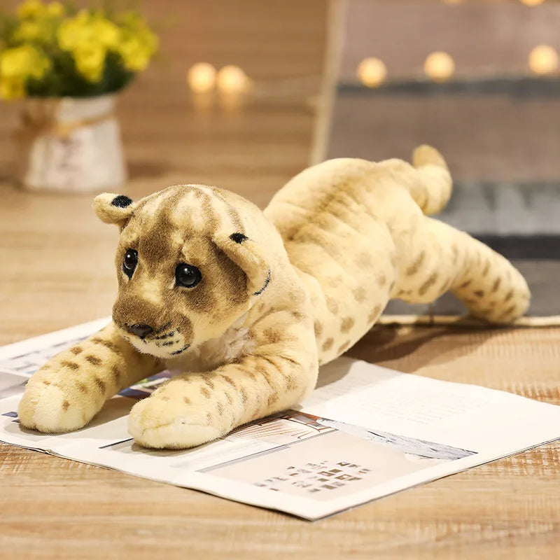 Plush lion toy lying on a newspaper with a blurred indoor background