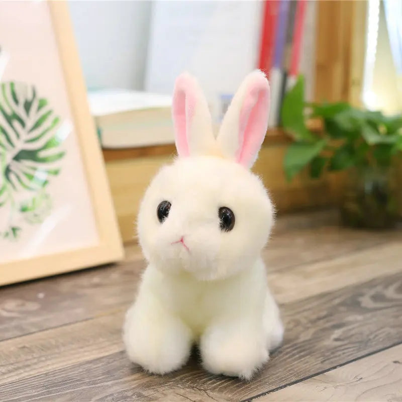 White plush rabbit toy on a wooden floor with a blurred background