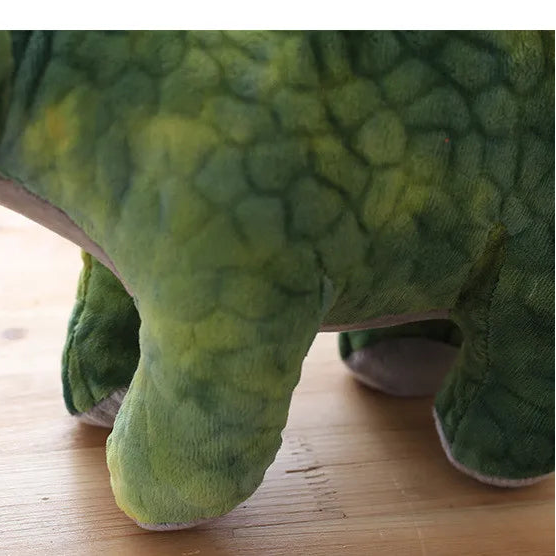 Close up off the feet of a soft plush stegosaurus dinosaur toy.