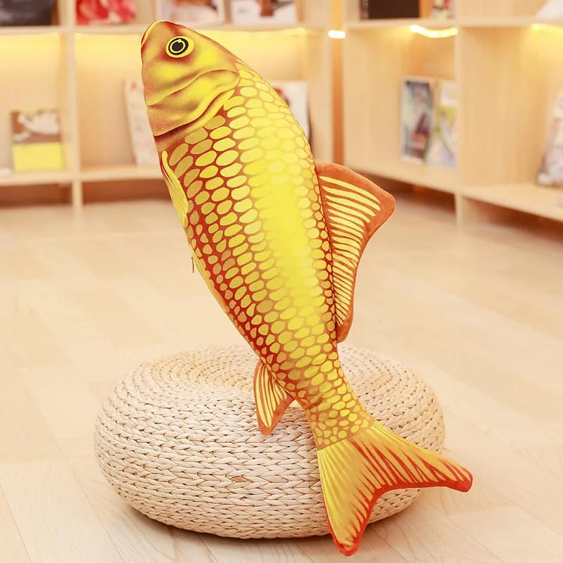 Orange and yellow koi fish soft toy with detailed scales and fins, displayed upright on a round woven stand