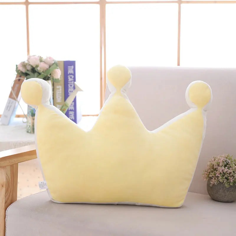 Yellow plush crown pillow with gentle pastel finish used as a decorative cushion