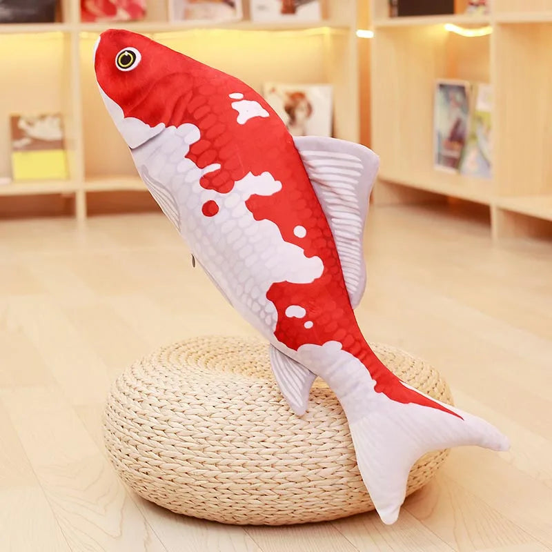 White and orange koi fish soft toy with large red patches, displayed upright on a round woven stand
