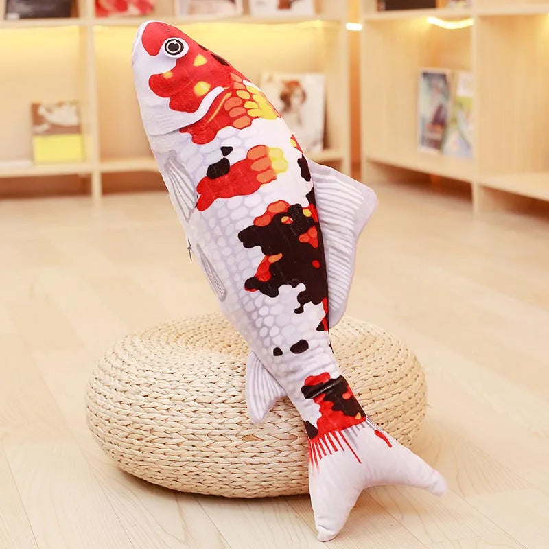 White koi fish soft toy with orange and black markings, displayed upright on a round woven stand