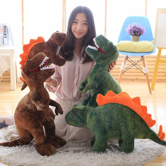 Woman holding and a green and brown dinosaur plush toy with two more dinosaurs on the floor in front of her.
