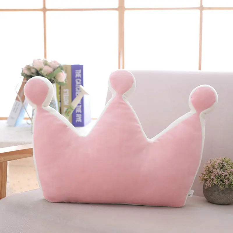 Pink plush crown pillow displayed upright as a playful nursery décor piece