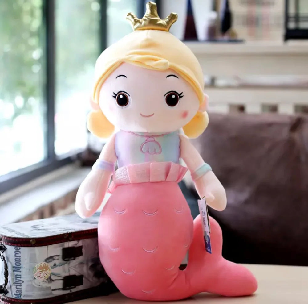 Plush toy mermaid with a crown on a table