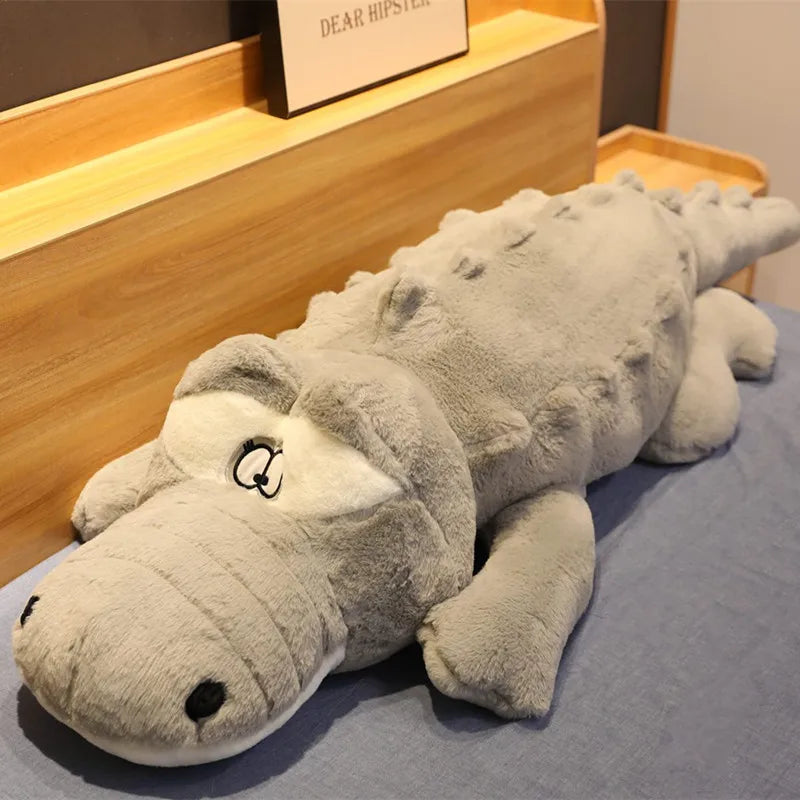 Big soft plush grey crocodile on a soft surface.