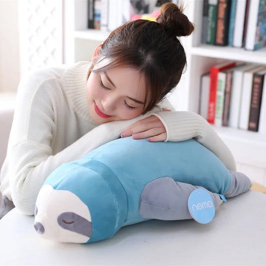 Woman lying with her head on a soft plush sloth toy.