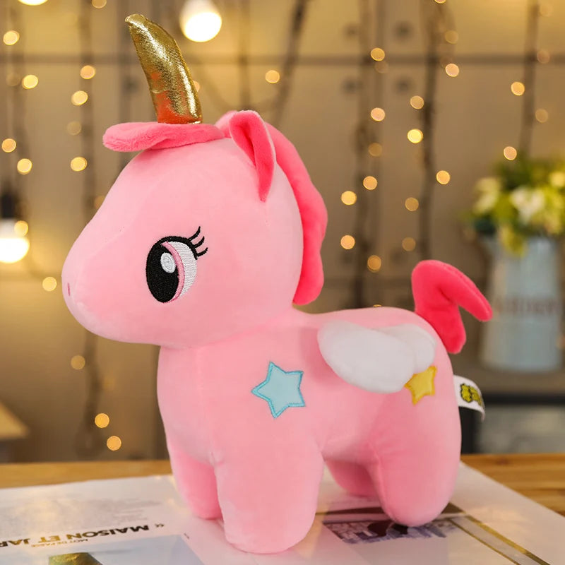 Pink unicorn plush toy with a gold horn on a magazine with a blurred background