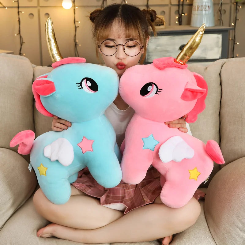 Woman holding two unicorn soft plush toys on a comfy chair.