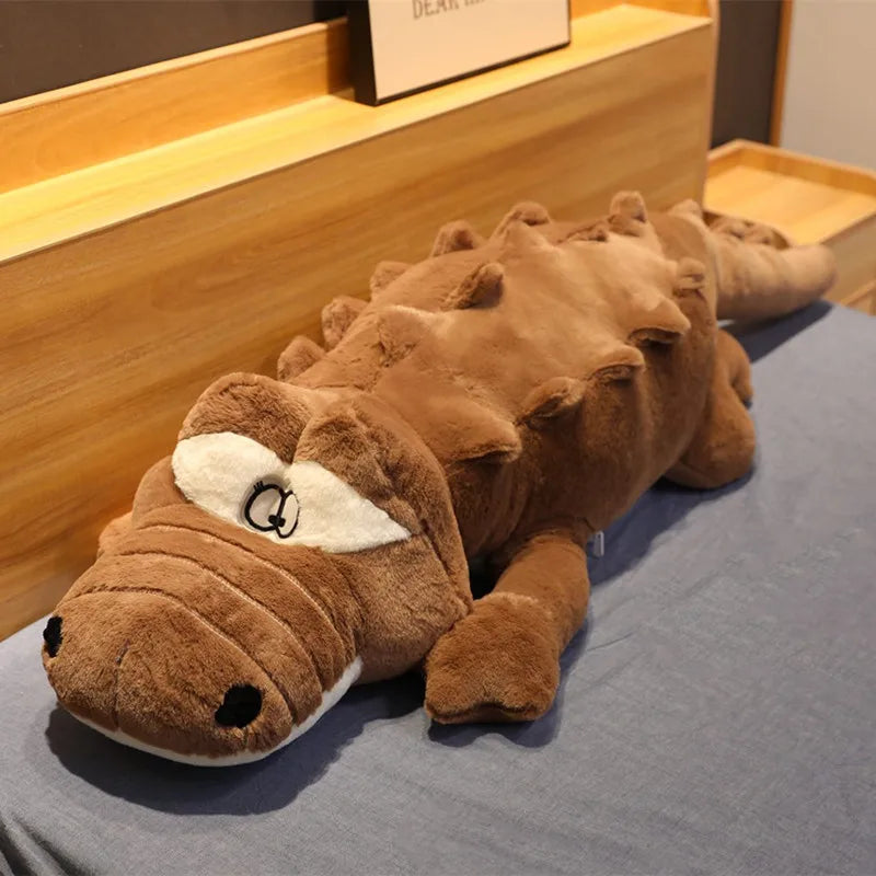 Big soft plush brown crocodile on a soft surface.