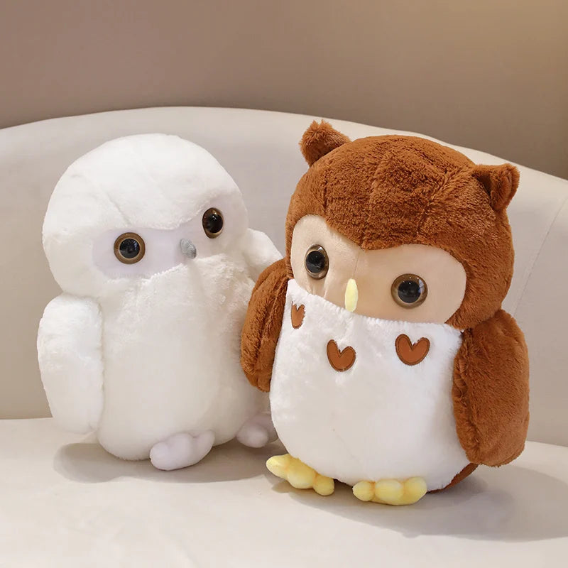 Two plush owl toys, one white and one brown with heart patterns, on a light background.