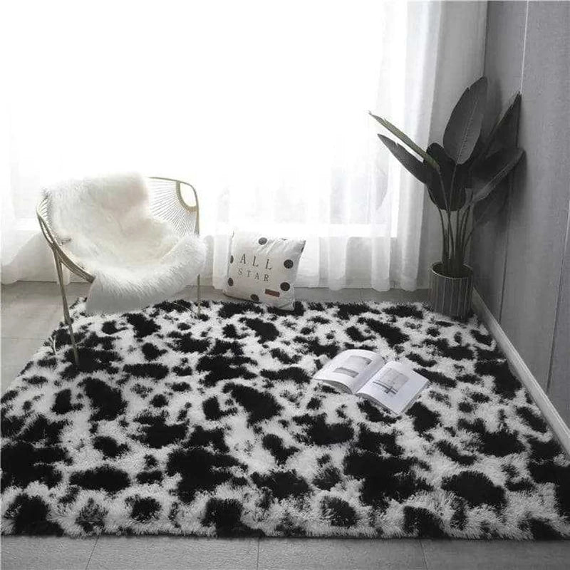 Black and white cow print rectangular plush rug placed on the floor in a cosy environment