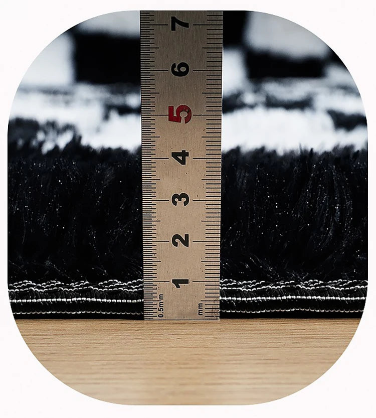 Close-up of black and white textured rug with a ruler for scale.