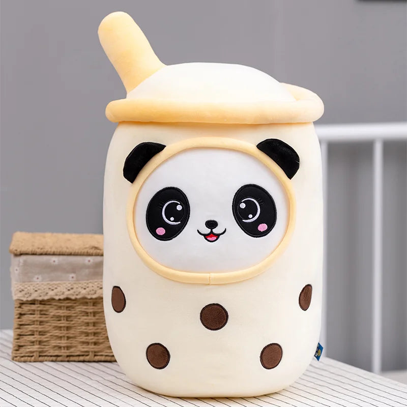 Panda bubble tea plush toy in soft yellow with smiling panda face and brown tapioca details on a neutral background.