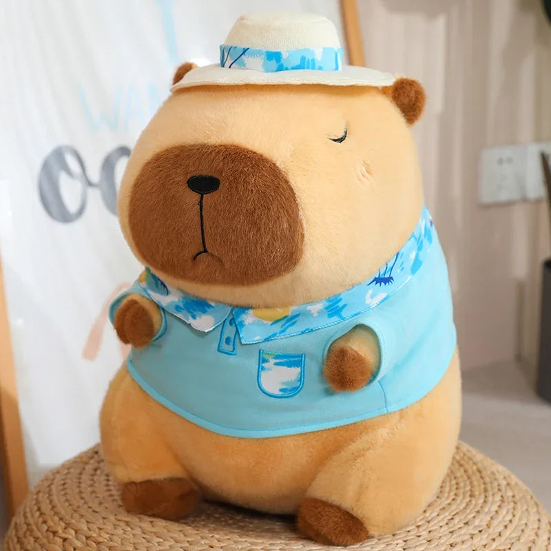 Capybara plush soft toy in blue outfit with matching hat and peaceful facial expression