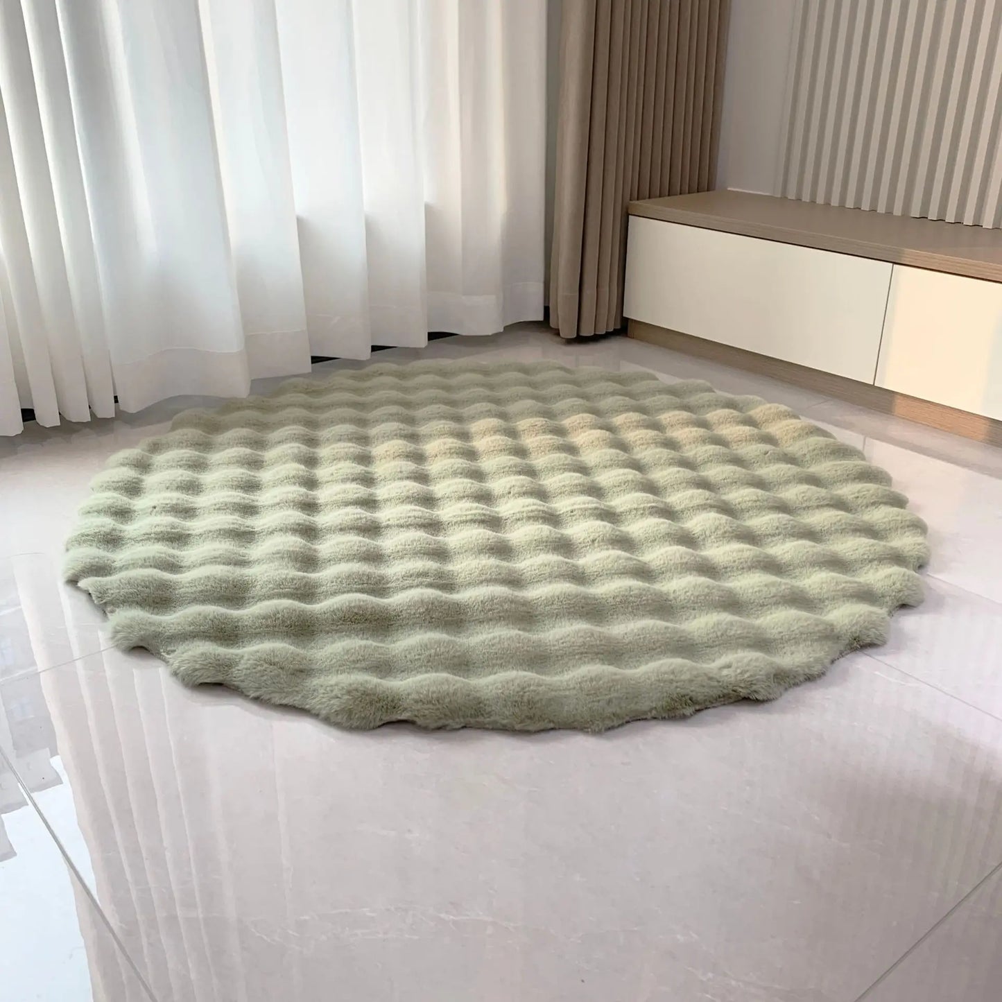 Sage green round bubble velvet plush rug placed on a light tiled floor by a window