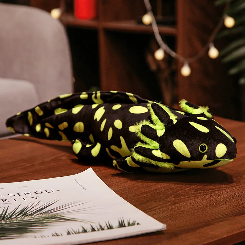 Plush toy resembling a black axolotl with a spotty pattern on a wooden surface.