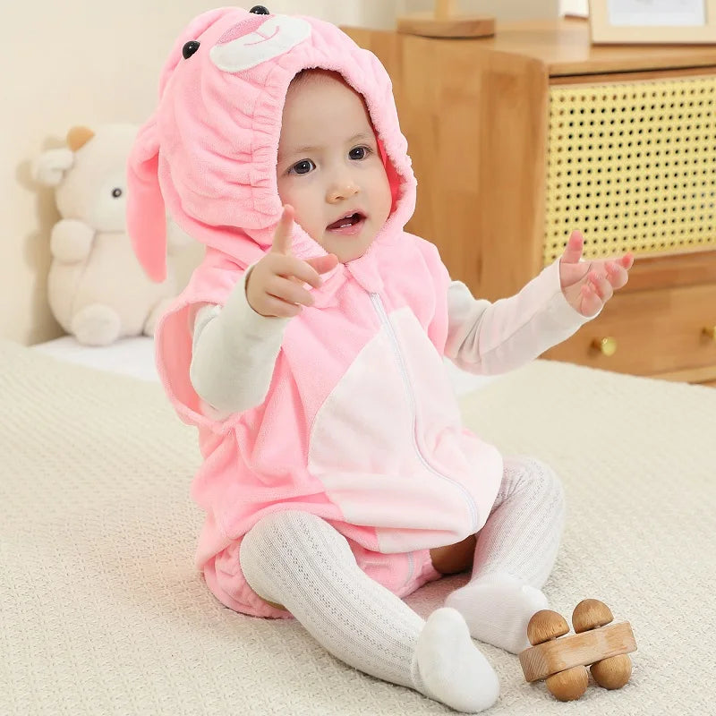 Baby wearing a pink bunny hooded onesie on a white surface. 