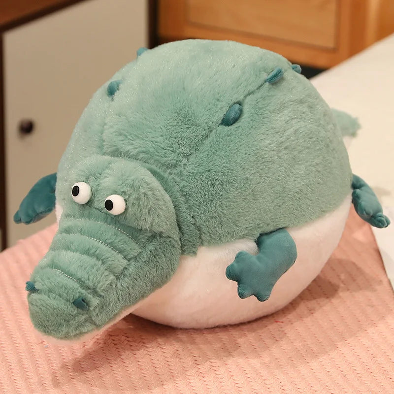 Plush toy crocodile on a pink blanket