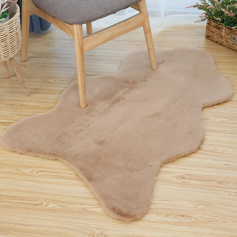 Beige fun-shaped faux rabbit fur rug placed on a wooden floor beneath a chair